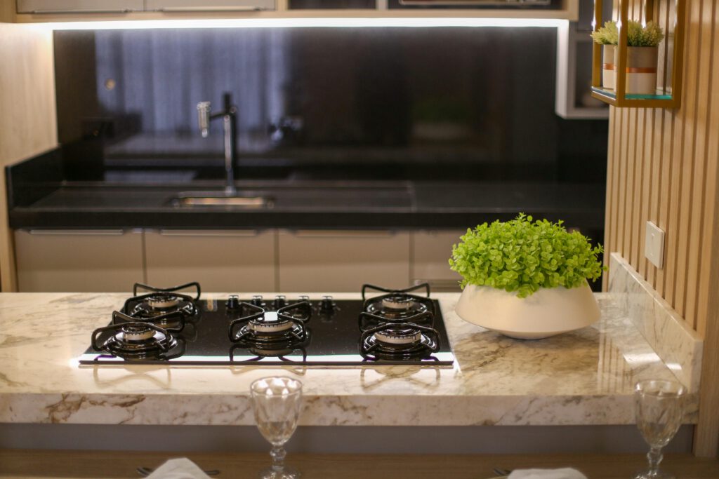 A stylish kitchen featuring a gas stove, marble top, and indoor plants. Perfect for home interior inspiration.